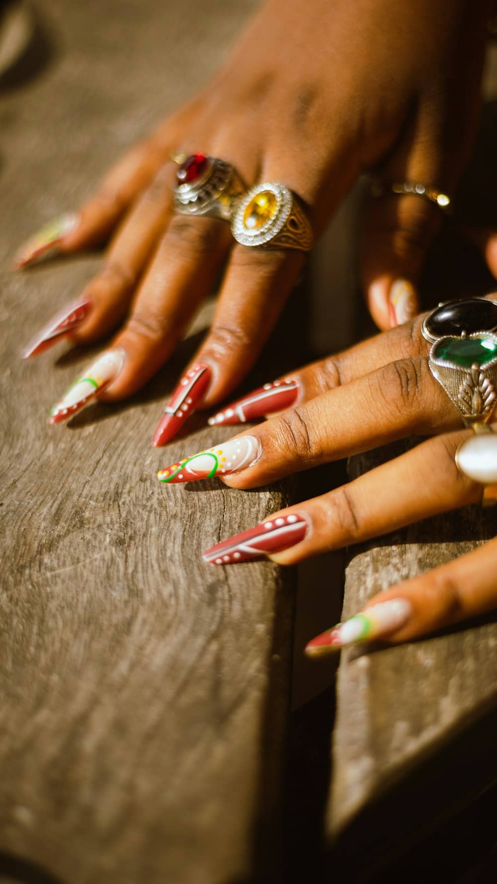 Hands with red festive nail art and rings